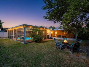 a house with a pool and a table and chairs at Largo Pool House Firepit Pet Friendly in Largo