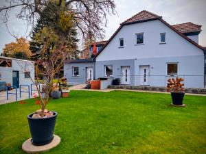 una casa blanca con un árbol en un patio en Schlafort, en Porta Westfalica