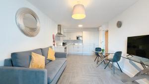 a living room with a blue couch and a glass table at Broc House Suites in Dublin