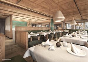 a restaurant with white tables and chairs and wooden ceilings at Hotel Fil Da Mont in Selva di Val Gardena