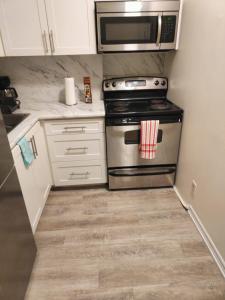 a kitchen with a stove and a microwave at Full Downtown Access-Central Location-Self Checkin in Toronto