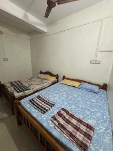 two twin beds in a room withthritisthritisthritisthritisthritisthritisthritisthritisthritis at Eden homes in Honāvar +2 photos