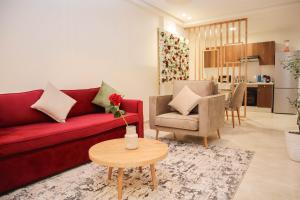 a living room with a red couch and a table at R108- Gorgeous & Cosy Aprt with Wifi, Parking and Gym at the heart of Bourgogne in Casablanca-Port