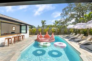 an outdoor swimming pool with a pool noodle bar and chairs at Lux 6br5ba, Htd Pool, Hot Tub, Game Rm Sleeps 22 in West Bradenton