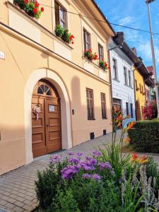 a building with a door and flowers in front of it at Apartment in a historical house in the center of Levoča in Levoča
