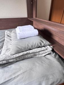a bed with two towels on top of it at FukuStay CCB1-201 福居 地下鉄駅徒歩2分 in Fukuoka