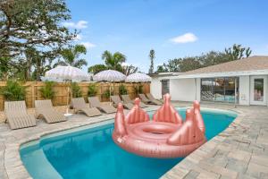 a pool with a pink inflatable raft in the middle at Lux 6br5ba, Htd Pool, Hot Tub, Game Rm Sleeps 22 in West Bradenton