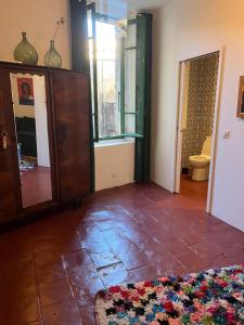 a living room with a tile floor and a mirror at Belle maison Centre Sérignan in Sérignan