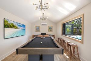 a billiard room with a pool table and stools at Lux 6br5ba, Htd Pool, Hot Tub, Game Rm Sleeps 22 in West Bradenton
