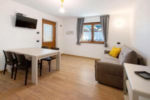 ein Wohnzimmer mit Tisch und Couch in der Unterkunft Appartamenti Via Dell'Asilo in Isolaccia