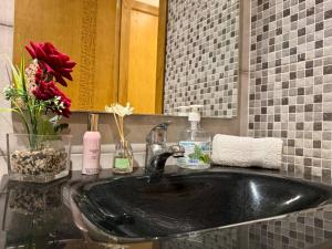 a bathroom with a black sink and a mirror at Comfort & Style Apartment in Kenitra