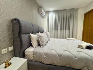a bedroom with a large bed and a window at Comfort & Style Apartment in Kenitra