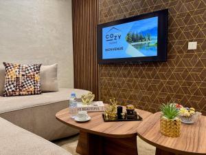 a room with a couch and a tv on a wall at Comfort & Style Apartment in Kenitra