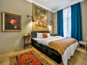 a bedroom with a bed and a painting on the wall at Timeless Prague Apartment by House of Huxe in Golčŭv Jeníkov