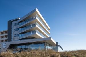 ein Gebäude mit Glasfenstern an der Seite in der Unterkunft Droomsuites Egmond aan Zee 4 personen by Droomvilla in Egmond aan Zee