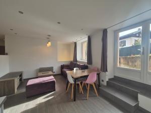 un soggiorno con un tavolo e un divano di Charmant 2 pièces avec jardin - Hyper centre BSM a Bourg-Saint-Maurice