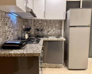 a kitchen with a sink and a stove top oven at Comfort & Style Apartment in Kenitra