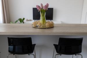 a table with two chairs and a vase with flowers at Harmony in Jelgava