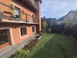 un cortile vuoto accanto a un edificio con un balcone di Charmant 2 pièces avec jardin - Hyper centre BSM a Bourg-Saint-Maurice