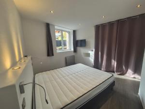 un letto in una stanza con una finestra di Charmant 2 pièces avec jardin - Hyper centre BSM a Bourg-Saint-Maurice
