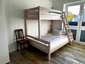 un lit superposé avec une échelle et une chaise dans une chambre dans l'établissement Haus "Friesland 10", Am Alten Deich 15c, à Dangast