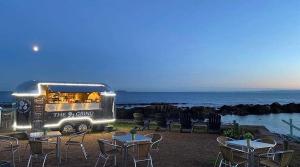 a food truck with tables and chairs in front of the ocean at THE COASTAL INN ACCOMMODATIONs in Cellardyke +17 photos