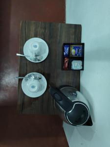 Un estante de madera con dos platos blancos y un fregadero. en HOTEL Makarios, en Shillong