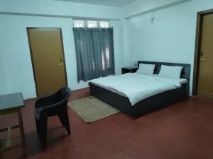 Un dormitorio con una cama, una mesa y una silla. en HOTEL Makarios, en Shillong 69 fotos más