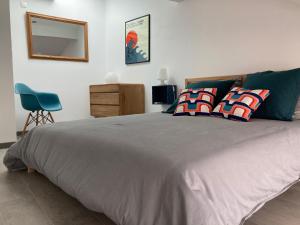 a bedroom with a large bed and a blue chair at Charmante maison à 200m de la plage in Hossegor