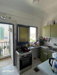 a small kitchen with a stove and a window at Sharing flat for LADIES ONLY in Sharjah