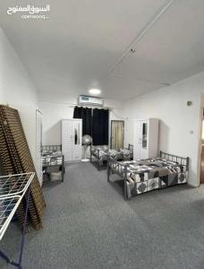 a room with several beds and a couch in it at Sharing flat for LADIES ONLY in Sharjah