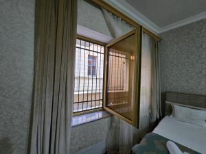 a bedroom with a window with a bed and a mirror at Sarp Hotel in Baku