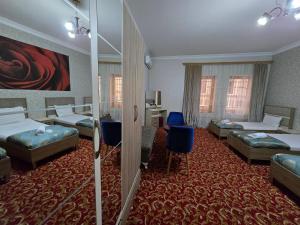 a hotel room with two beds and two blue chairs at Sarp Hotel in Baku