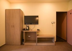 a room with a desk with a tv and a cabinet at Irroi Kaziranga in Kāziranga