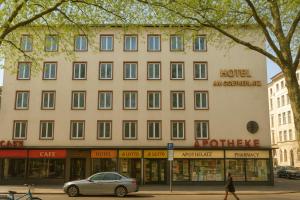 a building with a car parked in front of it at Hotel Mons am Goetheplatz in Munich