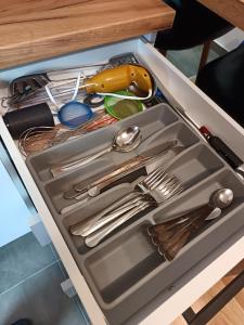 a drawer filled with utensils in a drawer at Orca Apartman in Jagodina