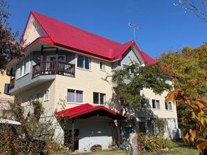 a large white house with a red roof at Stardew in Otari