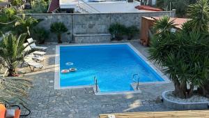 a large blue swimming pool in a yard at Cittadella Asprovalta 3BR - private pool in Asprovalta