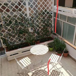 een patio met 2 stoelen en een hek met planten bij B&b Il mattarello in Bologna