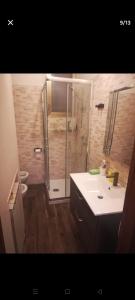 een badkamer met een douche en een witte wastafel bij B&b Il mattarello in Bologna