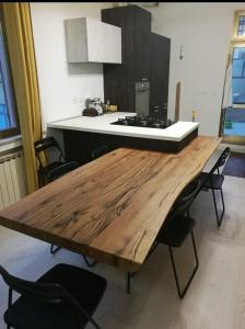 een keuken met een houten tafel met stoelen en een fornuis bij B&b Il mattarello in Bologna
