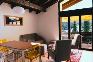 a living room with a table and chairs at Casa Laret 6-12 in Laax-Murschetg