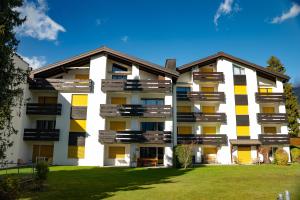an apartment building with yellow and white at Casa Laret 6-12 in Laax-Murschetg