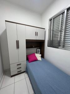 a small bedroom with a bed and a cabinet at Casa de Mainha - Vila Mariana - unidade 1 in Sao Paulo
