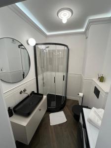 Cozy and quiet apartment in the city centre في بوزنان: حمام مع دش ومغسلة ومرآة