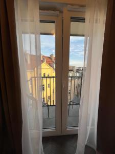 Cozy and quiet apartment in the city centre في بوزنان: شباك مع ستائر وإطلالة على مدينة