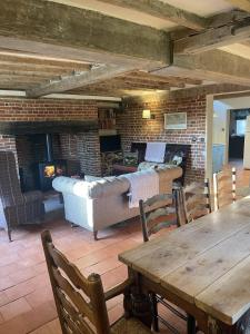 a living room with a couch and a fireplace at Park Farm in Thornham Magna