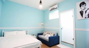 1 dormitorio azul con 1 cama y 1 silla azul en Kaohsiung Giethoorn, en Kaohsiung