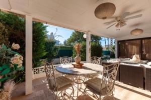 a patio with a table and chairs and a ceiling fan at Villa Soleil Et Douceur in La Seyne-sur-Mer