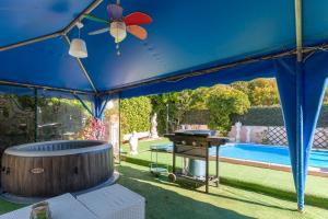 a blue tent with a grill and a pool at Villa Soleil Et Douceur in La Seyne-sur-Mer